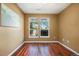 This bedroom features warm-toned walls, hardwood floors, a large window, and wall decor at 10184 Park Meadows Dr # 1102, Lone Tree, CO 80124