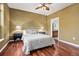 A calm bedroom suite featuring lamps, wood floors, a ceiling fan, and a glimpse into the bathroom at 10184 Park Meadows Dr # 1102, Lone Tree, CO 80124