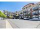 Apartment building exterior with brick accents, balconies, and parking area at 10184 Park Meadows Dr # 1102, Lone Tree, CO 80124