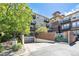 Apartment building exterior with brick accents, gated entrance, and lush landscaping at 10184 Park Meadows Dr # 1102, Lone Tree, CO 80124