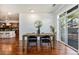 Open-concept dining area with view to kitchen, bright space with warm wood floors and access to balcony at 10184 Park Meadows Dr # 1102, Lone Tree, CO 80124
