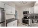 Bright kitchen features stainless steel appliances, granite countertops, and white cabinetry at 2664 Dahlia St, Denver, CO 80207
