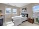 Bright bedroom with two windows, a bed with blue pillows, and a wicker box at 9592 Keystone Trl, Parker, CO 80134
