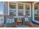 Cozy outdoor seating area on a covered deck with decorative lanterns and pillows at 9592 Keystone Trl, Parker, CO 80134