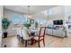 Bright dining room with vaulted ceilings, a large table, and comfortable seating next to living room at 9592 Keystone Trl, Parker, CO 80134