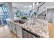 Kitchen island with granite countertop, stainless steel dishwasher, and an open view of the living area at 9592 Keystone Trl, Parker, CO 80134