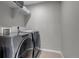 Laundry room with stainless steel washer and dryer and white shelves at 9592 Keystone Trl, Parker, CO 80134