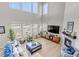 Spacious living room with high ceilings, fireplace, large windows, and stylish furnishings at 9592 Keystone Trl, Parker, CO 80134