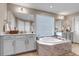 Elegant bathroom with a large tub, dual vanities, and neutral finishes at 9592 Keystone Trl, Parker, CO 80134