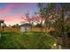 Scenic backyard featuring lush green grass, garden, shed, and private wooden fence at sunset at 4924 S Flower Way, Littleton, CO 80123