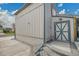 View of the home exterior with vertical siding, a basement access door and a set of stairs leading to the entrance at 4924 S Flower Way, Littleton, CO 80123