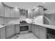 Bright kitchen with stainless steel appliances, white subway tile backsplash, and gray cabinetry at 4924 S Flower Way, Littleton, CO 80123