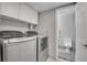 Convenient laundry room featuring front loading washer/dryer and upper cabinets at 4924 S Flower Way, Littleton, CO 80123