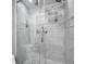 Luxurious shower with marble tiling, multiple showerheads, and glass door enclosure at 4924 S Flower Way, Littleton, CO 80123