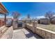 View of an outdoor grill with stone surround, as well as a large backyard with a shed at 3090 W Longfellow Pl, Denver, CO 80221