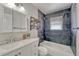 Bathroom featuring dark tile walls, a shower over tub, and a modern vanity at 3090 W Longfellow Pl, Denver, CO 80221