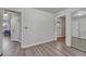 Neutral bedroom with wood floors, mirrored closet, and views into other rooms at 3090 W Longfellow Pl, Denver, CO 80221