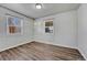 Bright bedroom featuring wood-look flooring and two windows allowing for natural light at 3090 W Longfellow Pl, Denver, CO 80221