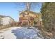 Exterior view of a home showcasing a wooden deck, stairs, and a spacious yard surrounded by mature trees at 9383 Cobblecrest Dr, Highlands Ranch, CO 80126