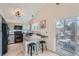 Modern kitchen with light gray cabinets, black appliances, breakfast bar, and deck access at 9383 Cobblecrest Dr, Highlands Ranch, CO 80126