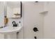 Modern bathroom featuring a white sink, sleek black fixtures, and minimalist shelving for storage at 5330 S Windermere St, Littleton, CO 80120