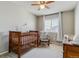 Bedroom room with wooden baby crib, ceiling fan and natural light at 10518 Hyacinth Pl, Highlands Ranch, CO 80129