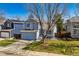 Inviting home with a well-maintained lawn, mature tree, and a neatly arranged front garden at 10518 Hyacinth Pl, Highlands Ranch, CO 80129