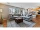 Spacious living room featuring a large gray sectional sofa, an ottoman, and a view of the staircase at 10518 Hyacinth Pl, Highlands Ranch, CO 80129