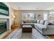Comfortable living room featuring a fireplace, a gray sectional sofa, and an ottoman at 10518 Hyacinth Pl, Highlands Ranch, CO 80129