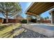 Landscaped backyard features a covered patio, large tree and a wood fence at 9668 Salem Ct, Highlands Ranch, CO 80130