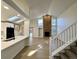 Open-concept living area with a brick fireplace, skylights, and stairs with carpet treads at 9668 Salem Ct, Highlands Ranch, CO 80130