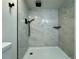 Updated shower features gray tiled walls, rainfall shower head, and black fixtures at 9668 Salem Ct, Highlands Ranch, CO 80130