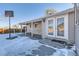 Backyard with basketball hoop, patio, and storage shed in winter at 2701 S Knox Ct, Denver, CO 80236