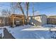 Backyard features a BBQ grill, storage shed, wooden fence, and snow covered ground at 2701 S Knox Ct, Denver, CO 80236