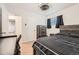 Bedroom with wood floors, windows, dresser, comfortable bed, and view to entry hall at 2701 S Knox Ct, Denver, CO 80236