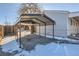 Carport at the back of the property with a gravel driveway and a glimpse of the house at 2701 S Knox Ct, Denver, CO 80236