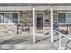 Front porch features stone detail, secure door, seating area, and number marker at 2701 S Knox Ct, Denver, CO 80236