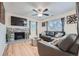 Inviting living room featuring stone fireplace, ceiling fan, hardwood floors and a comfortable leather sofa at 2701 S Knox Ct, Denver, CO 80236