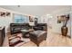 Living room with leather furniture, wood floors, and view to dining area at 2701 S Knox Ct, Denver, CO 80236