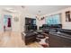 Living room with leather furniture, wood floors, and access to bedroom at 2701 S Knox Ct, Denver, CO 80236