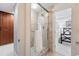 Modern bathroom featuring a glass-enclosed shower and neutral tile, seamlessly connected to the main bedroom at 8276 E 28Th Dr, Denver, CO 80238