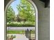 Front yard view framed by a stone archway from the front porch of the home at 8276 E 28Th Dr, Denver, CO 80238