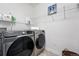 Functional laundry room with a modern, front-loading Samsung washer and dryer, plus ample shelving at 8276 E 28Th Dr, Denver, CO 80238