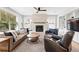 Comfortable living room with a stone fireplace, large windows and a ceiling fan at 8276 E 28Th Dr, Denver, CO 80238