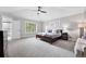 Spacious main bedroom with a ceiling fan, large windows, and an adjoining bathroom at 8276 E 28Th Dr, Denver, CO 80238