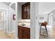 Stylish wet bar with wine storage, sink, custom cabinetry, and convenient access to the kitchen and dining area at 8276 E 28Th Dr, Denver, CO 80238