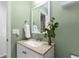 Bathroom featuring light green walls, granite counters, mirror and white cabinets at 10101 E 112Th Way, Commerce City, CO 80640
