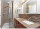 Bathroom features a glass shower, double sink vanity with granite countertop, and mosaic backsplash at 10101 E 112Th Way, Commerce City, CO 80640