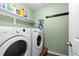 Laundry room featuring a washer and dryer, storage shelf, and laminate floors at 10101 E 112Th Way, Commerce City, CO 80640