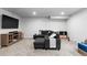 Cozy basement living room with a large dark couch, entertainment center, and a television at 10101 E 112Th Way, Commerce City, CO 80640